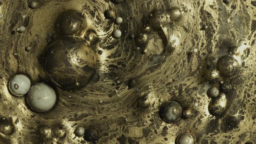 Rotating liquid gold colors with bubbles on water surface