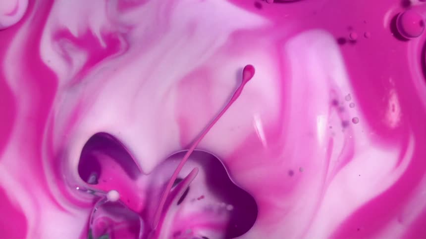 Swirling abstract pink colors mixing in oil bubbles