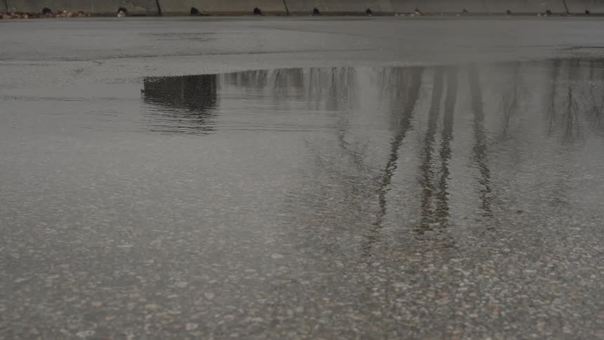 A car passing through a puddle of water on an asphalt