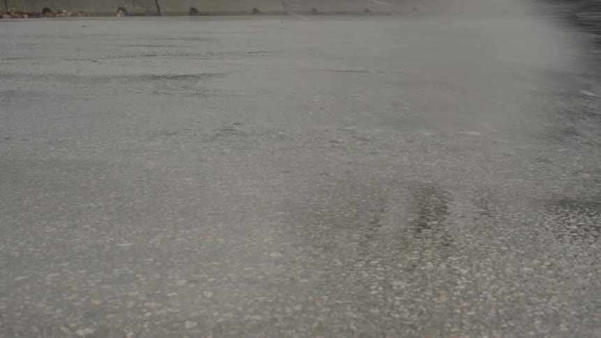 View of the road with puddles and cars passing by