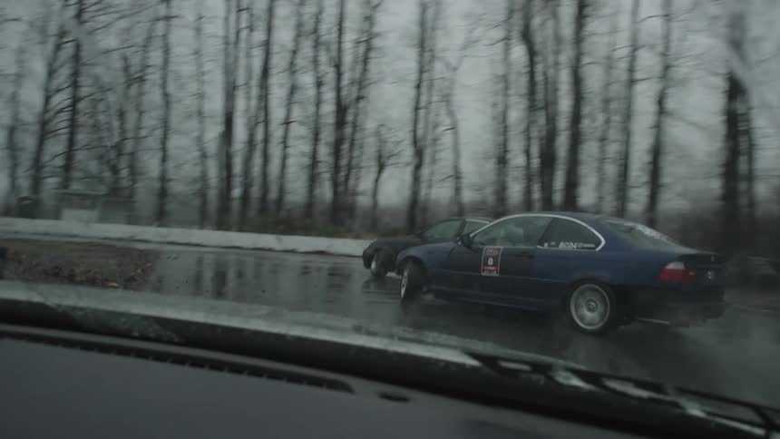 Automobiles are sliding on wet pavement as they race in the rain