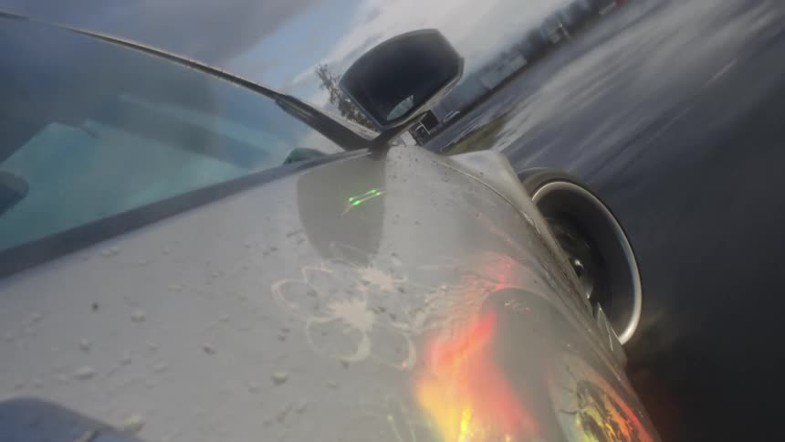 Point of view of a car racing on a track splashing through a puddle