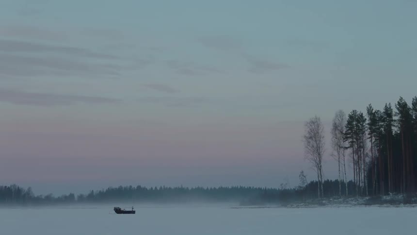 A sled sits on a frozen lake at sunrise