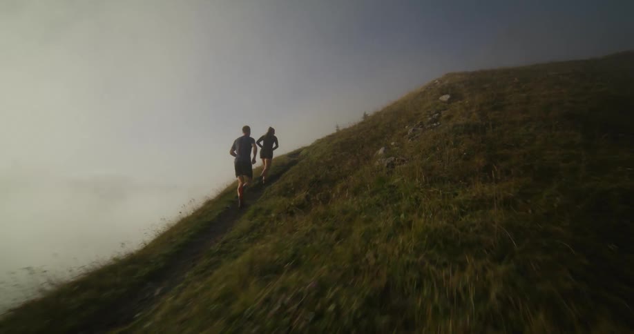 A man and woman run up the mountain