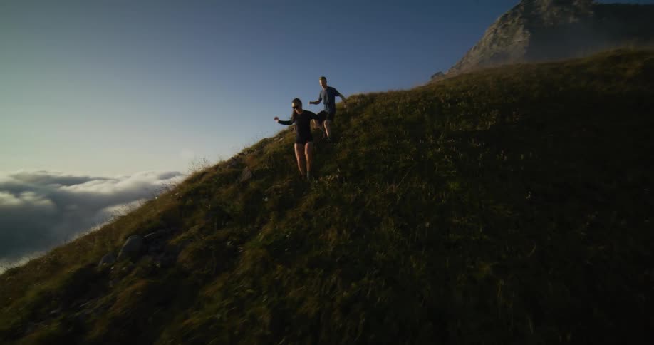 A woman and a man running down a hill
