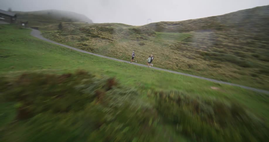 Three people are jogging on a trail by the lake