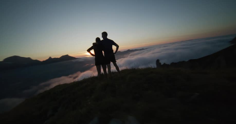 Aerial view of a young couple in the peak of a mountain