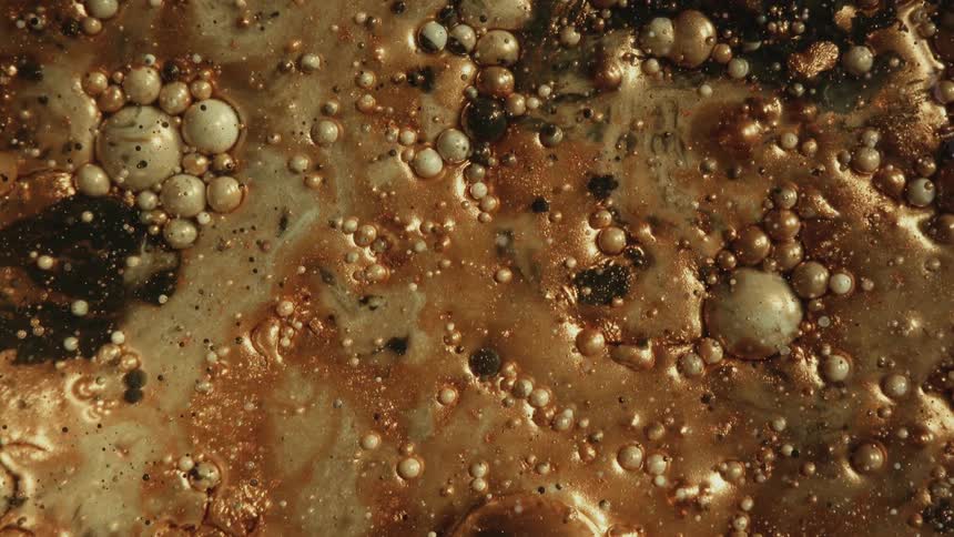 Metallic liquid copper colors with bubbles on water surface