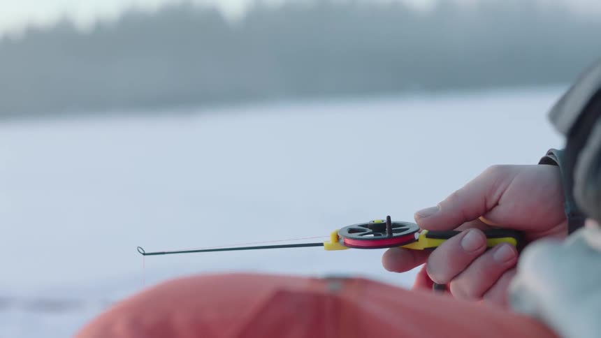 Person ice fishing on a very cold day