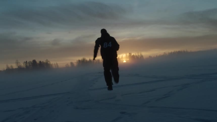 Man sprints on the snow at sunset