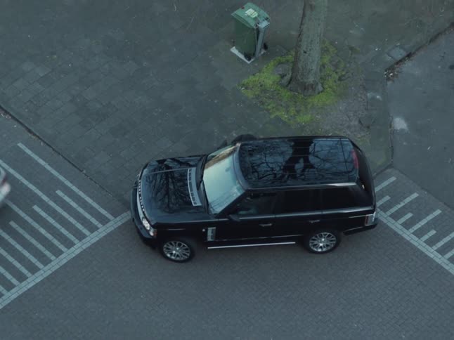Man approaches a vehicle in the city and walks away