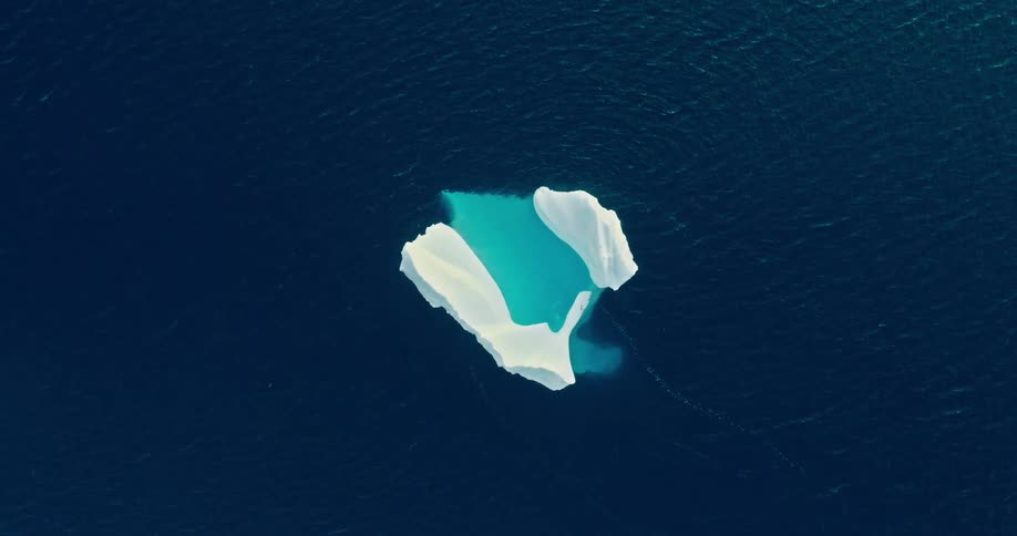 Aerial of an iceberg floating in the sea during a sunny day