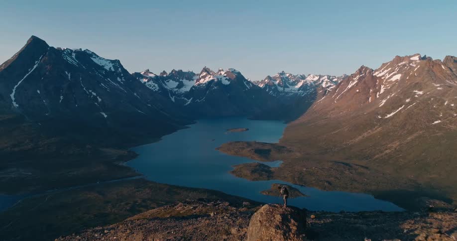 A group of hikers atop a mountain looking at a lake