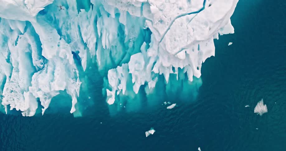 Aerial view of a drone flying over a large iceberg