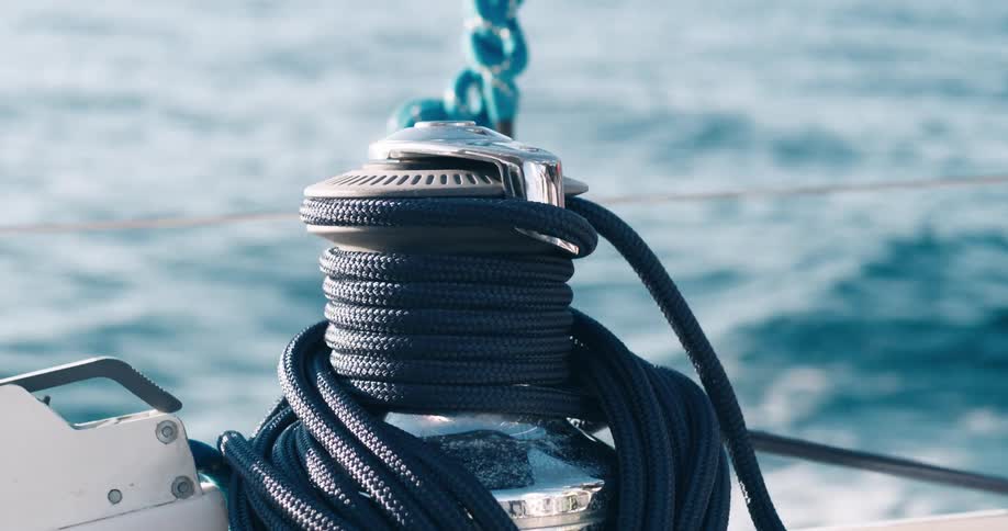 A rolled up rope attached to a chain is moving through the sea on what is probably a boat