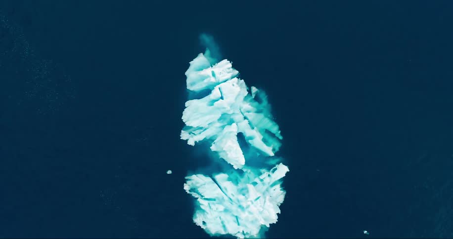 An iceberg in the middle of a clear blue ocean