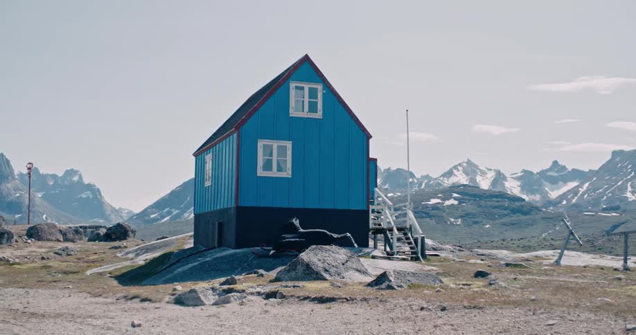 A small building on a hill close to the mountain