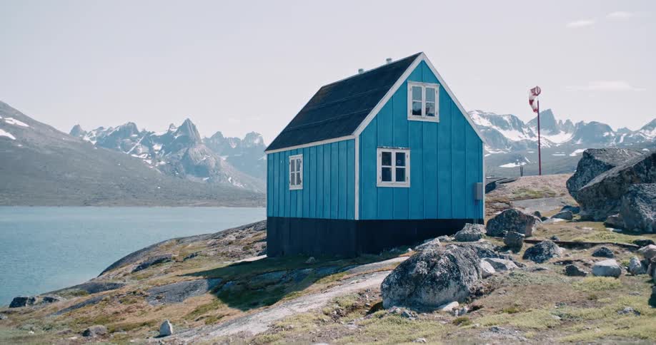 Small blue wooden house by a lake in Greenland