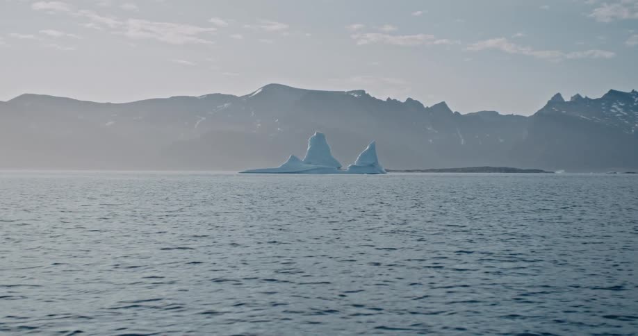A large iceberg on top of the sea and at the bottom there is a large mountain