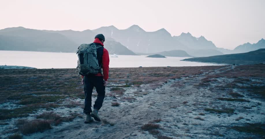 Man hiking near the shore of a lake in the mountains