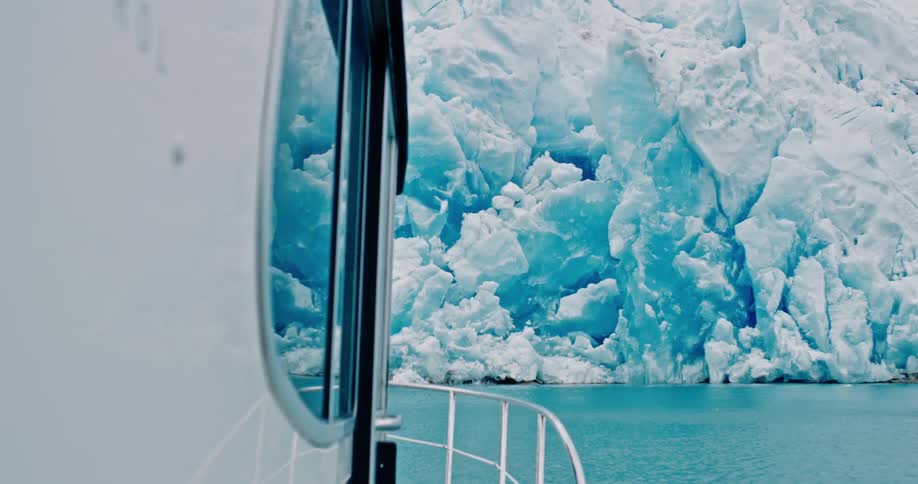 A large wall of ice is in front of a boat