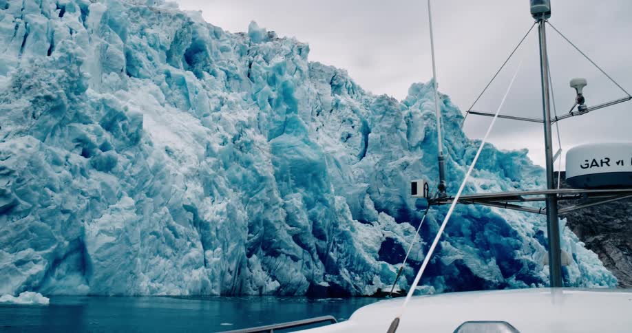View from inside a boat of a glacier amid the sea on a cloudy day