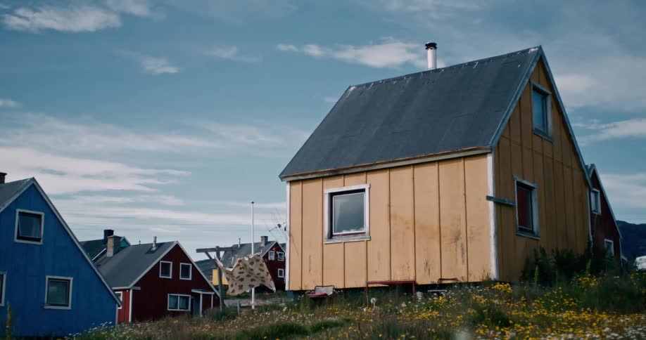 View of colorful wooden houses amidst fields in daylight