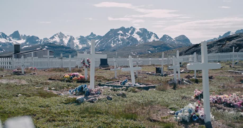 A well maintained cemetery surrounded by a white picket fence