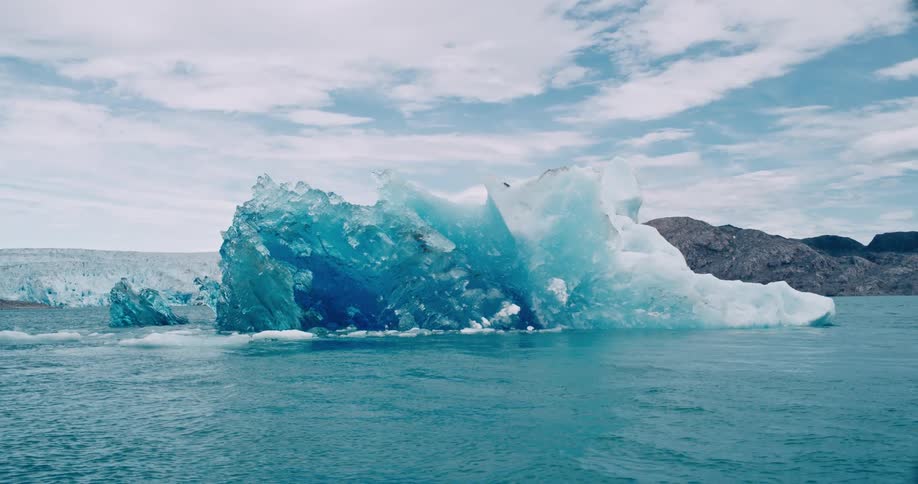 A melting iceberg floats of the arctic coast
