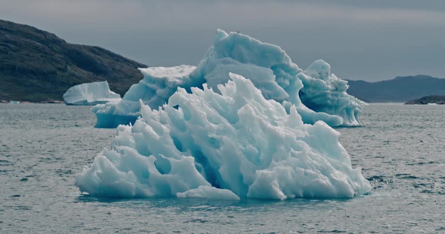 Melting icebergs float off the arctic coast