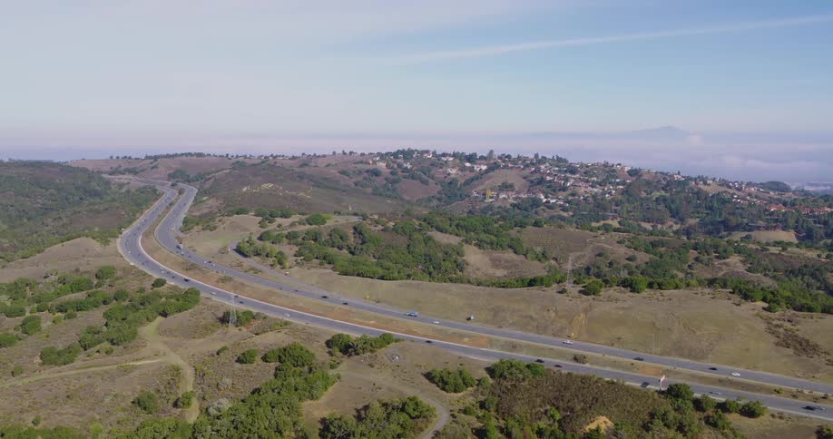 Landscape of moving cars on double lane roads at city outskirt during the day