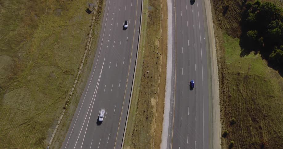 Aerial of highway without traffic during sunny day