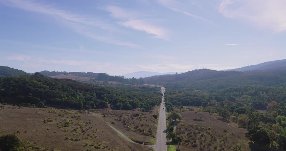 Panorama of a road amidst flowery fields and mountains