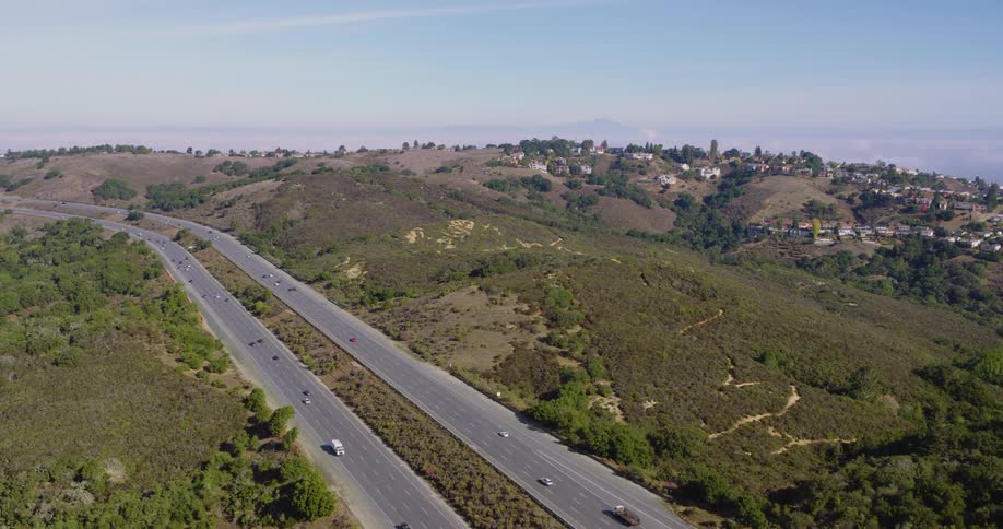 Vehicles driving on a highway through the hills