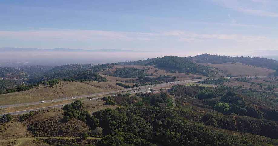 Aerial panorama of a road amidst mountains and forests
