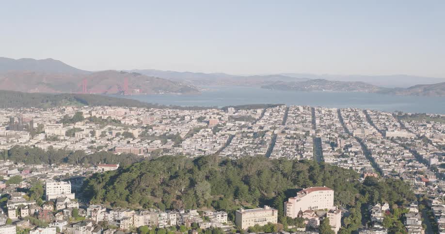 Aerial panorama of an urban city facing the sea and nestled amidst mountains