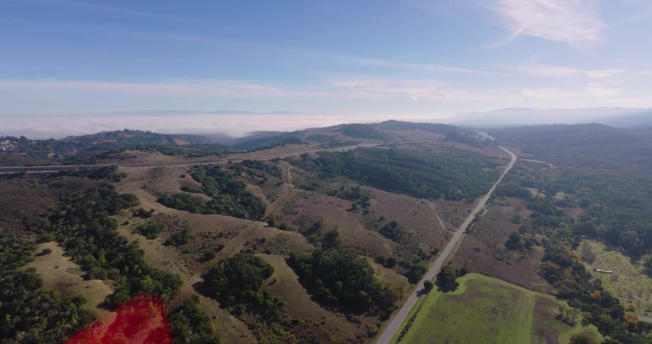 Aerial panorama of a mountain range and roads on a day with a blue sky