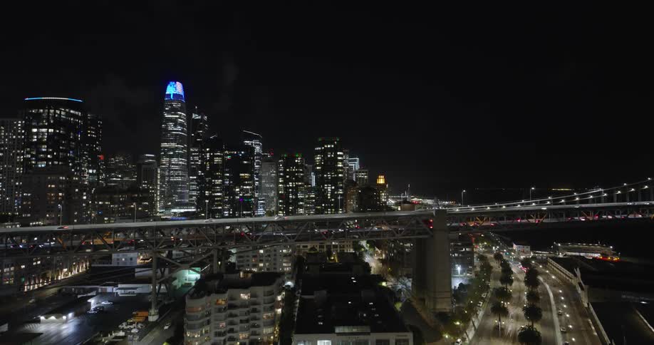 Aerial view of a coastal city at night illuminated by city lights