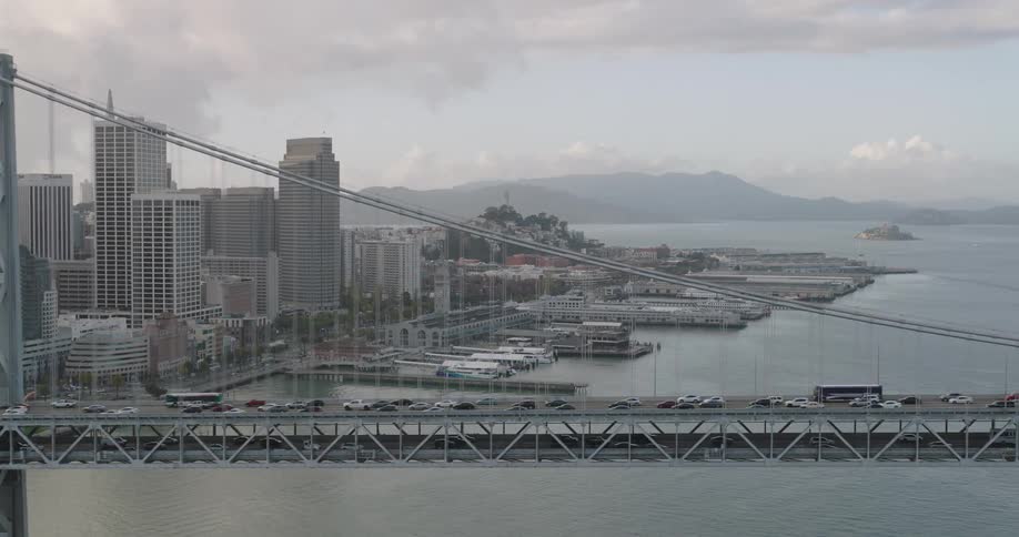 Panorama of a bridge under the sea connecting a metropolis with skyscrapers on a cloudy sky morning