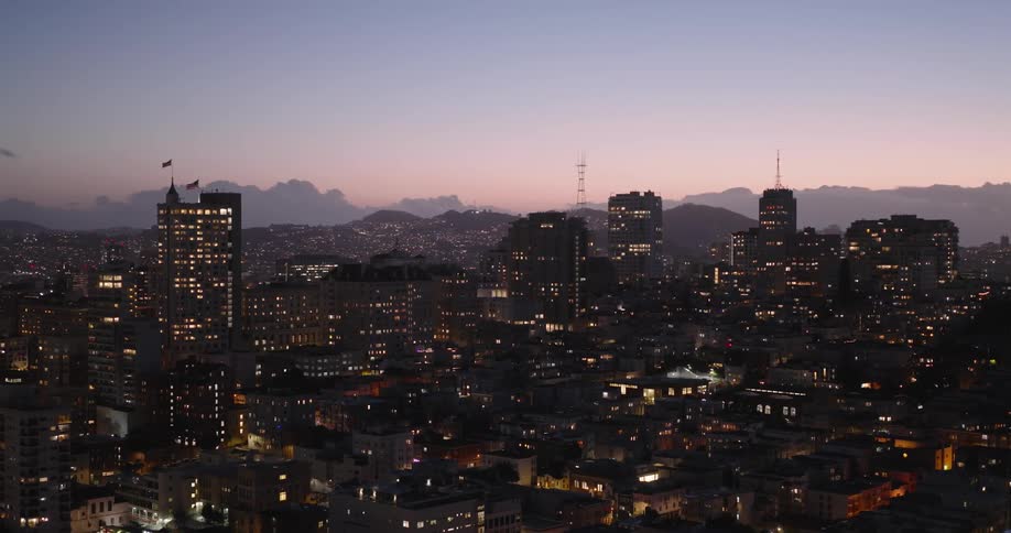 Aerial of illuminated buildings in the city at dusk