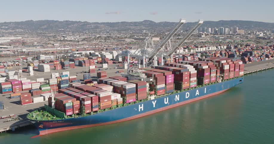A cargo ship filled with crates at the loading dock along the coast