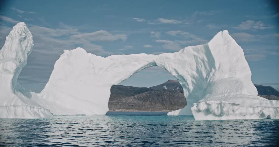 Panorama of an ice arch amidst the sea on a day with a blue sky