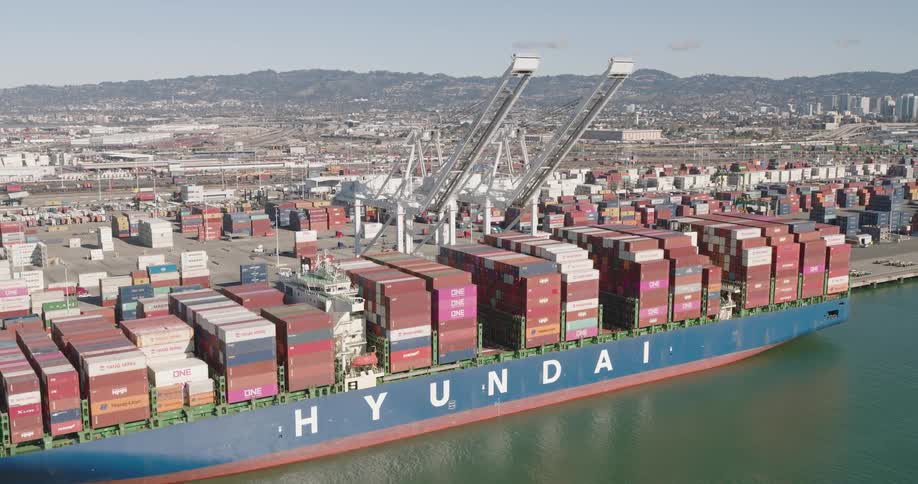 Aerial of a cargo ship docked at the port with containers on board