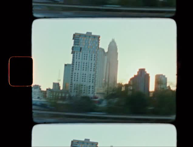 Landscape of skyscrapers from a moving vehicle at sunset
