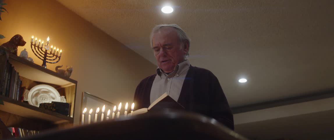A jewish man reads from a book during a religious ceremony