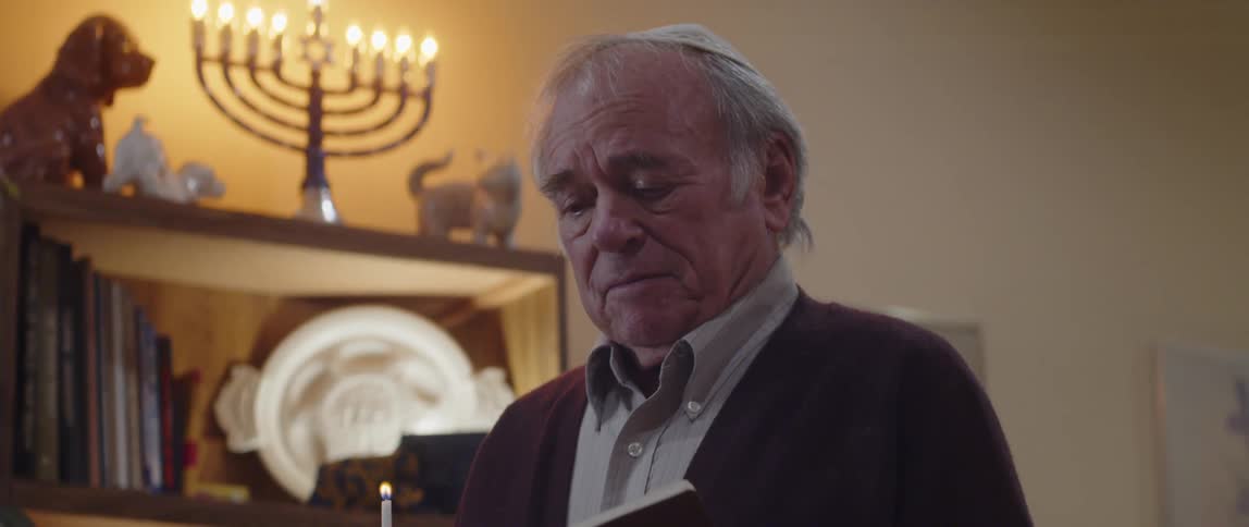 Elderly person lighting a candle and beginning to read with a bible