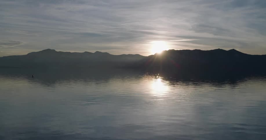 Sun sets over the mountains near the lake