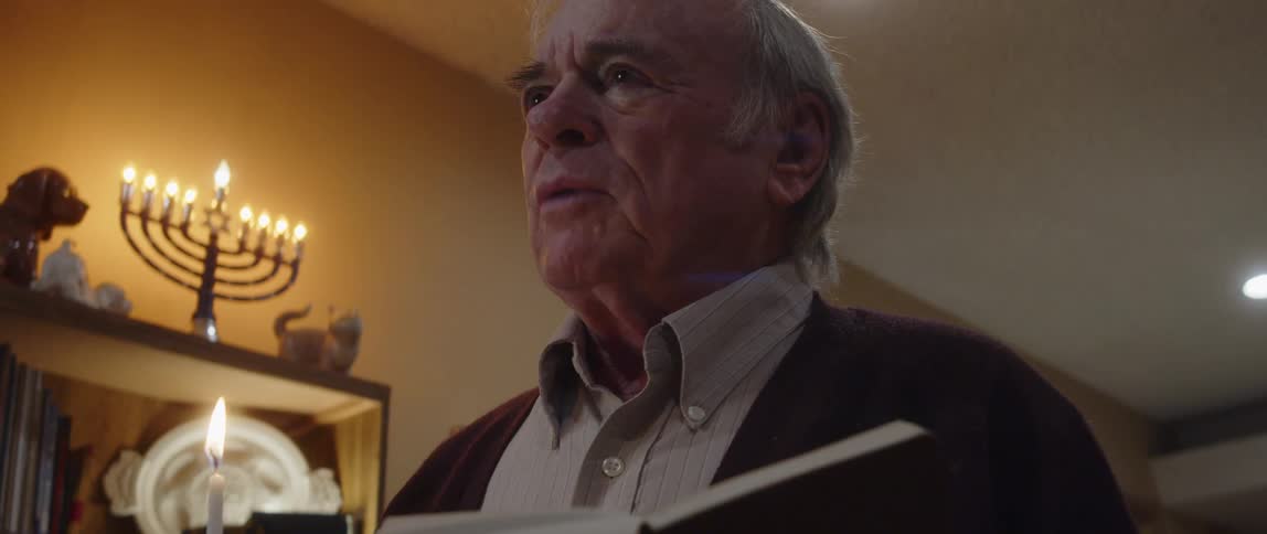 Portrait of an elderly person reading a bible inside a sanctuary