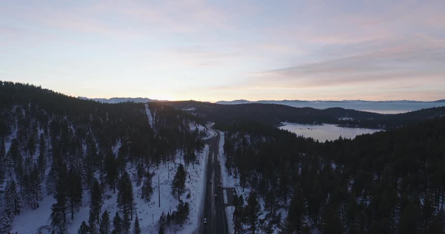 Cars travel on the highway past the snow