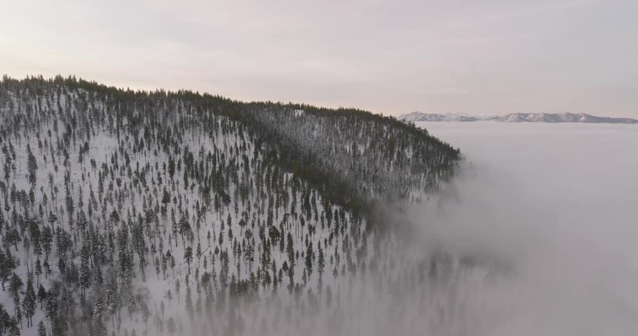 Aerial view of clouds over the mountain forests at winter